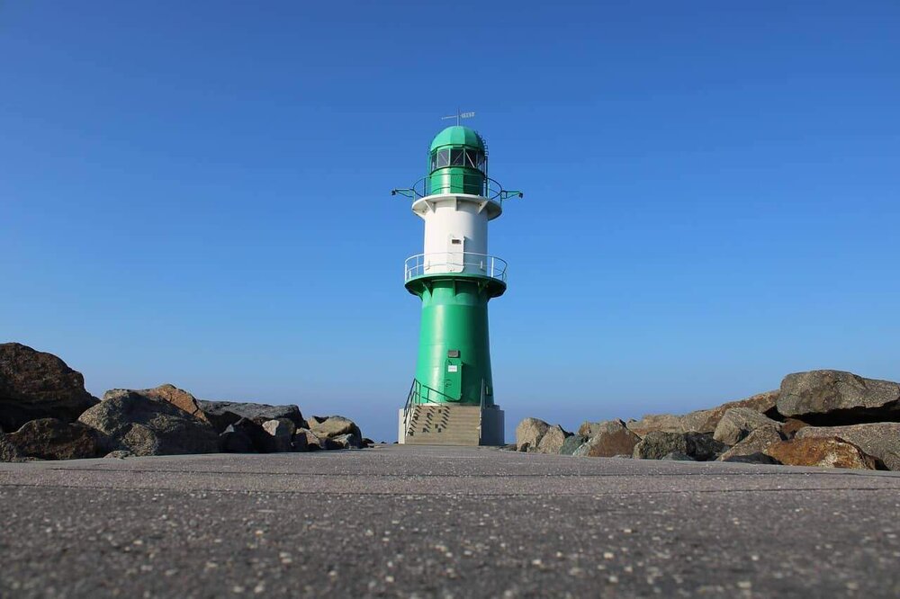 Grüner Leuchtturm auf einer Mole in Mecklenburg-Vorpommern