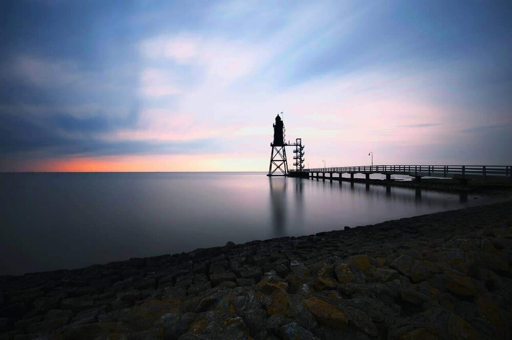 Steg und Seezeichen an der niedersächsischen Nordseeküste bei Abendlicht