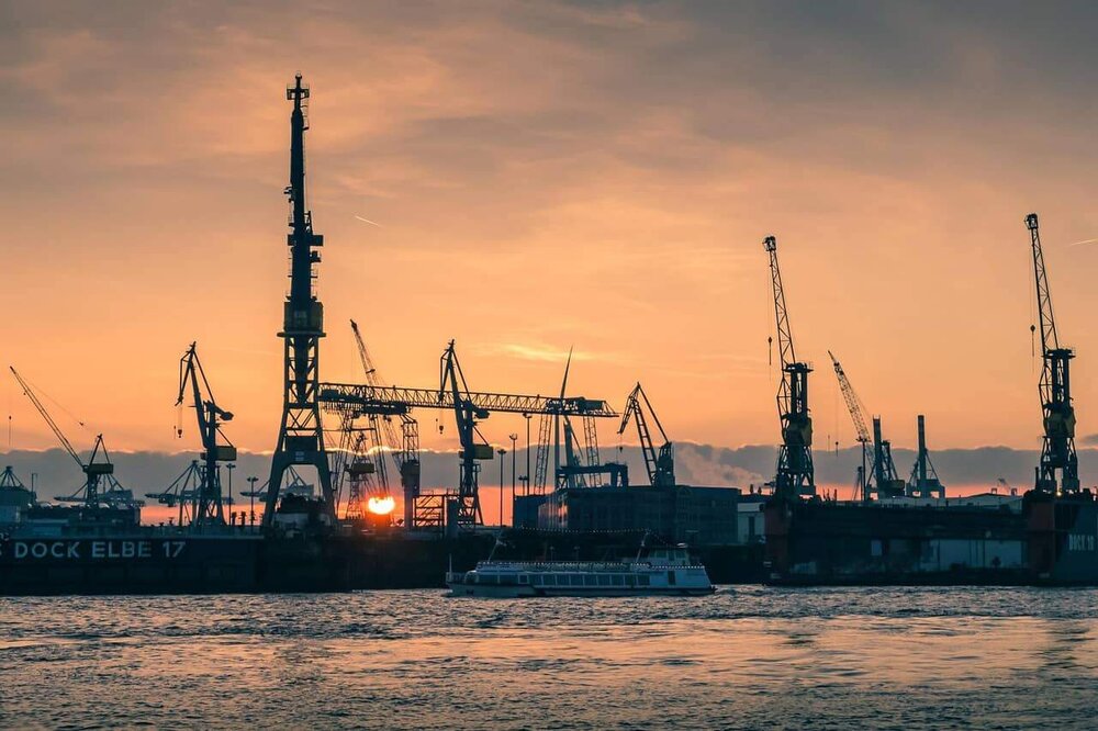 Hafenkräne und Schiff im Hamburger Hafen bei Sonnenuntergang